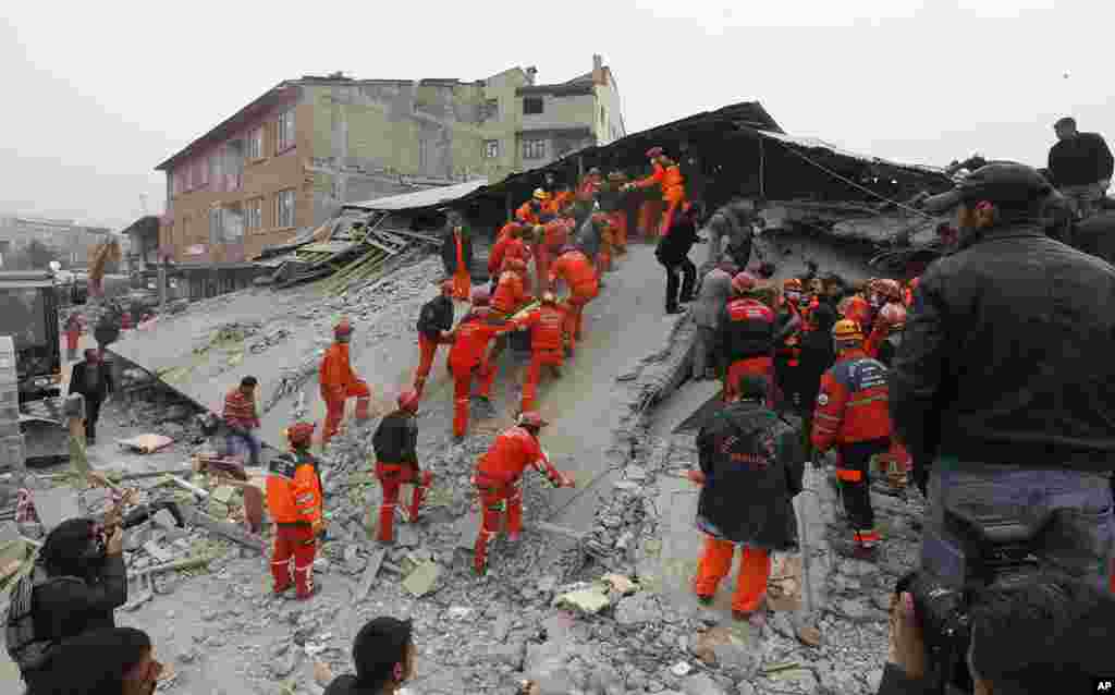 A rescue team carries a generator as they search for survivors under a collapsed building in Ercis, near the eastern Turkish city of Van, October 25, 2011. (Reuters)