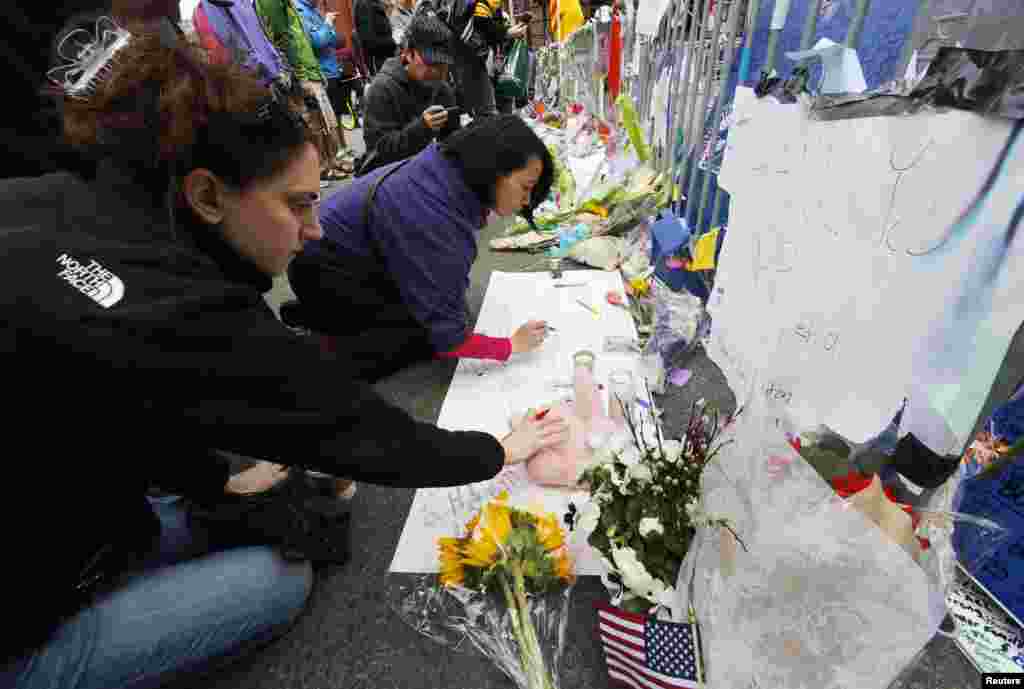 20일 미국 보스턴 테러 현장을 찾은 한 여성이 희생자를 추모하기 위해 놓인 인형을 만지고 있다.