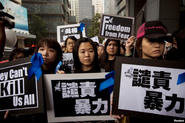 FILE - Staff members of Ming Pao newspaper take part in the march against violence on journalists in Hong Kong, March 2, 2014.