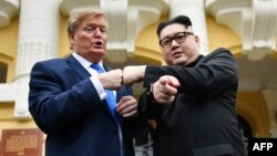 Dua orang yang mirip Presiden AS Donald Trump dan pemimpin Korut Kim Jong berpose di luar Opera House di Hanoi, Vietnam (22/2). Vietnam akan menjadi tuan rumah KTT kedua Trump-Kim akhir bulan ini.