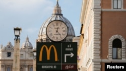 Una señalización muestra la dirección donde está el nuevo restaurante de McDonald's frente a la Plaza de San Pedro en Roma.
