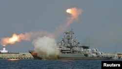 Russian warships fire during a naval parade rehearsal in the Crimean port of Sevastopol, July 25, 2014.