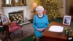 In this photo released Dec. 25, 2016, Britain's Queen Elizabeth II poses for a photo, sitting at a desk in the Regency Room of Buckingham Palace in London, after recording her traditional Christmas Day broadcast to the Commonwealth. 