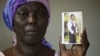 FILE - In this Monday, May 19, 2014 file photo, Martha Mark, the mother of kidnapped school girl Monica Mark cries as she displays her photo, in the family house, in Chibok, Nigeria. At least 11 parents of the more than 200 kidnapped Nigerian schoolgirls 