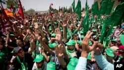 FILE - Palestinian students and supporters of the Hamas movement chant slogans during a rally near the West Bank city of Ramallah, April 26, 2016.