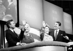 FILE - President Ronald Reagan, far right, first lady Nancy Reagan, right, Vice President George Bush and his wife, Barbara, react to cheers from the floor at the final session of the Republican National Convention in Dallas, Texas, Aug. 23, 1984.