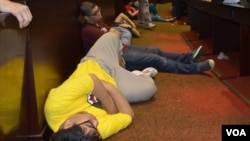 Sleepy students take a nap on the floor of a lecture hall.