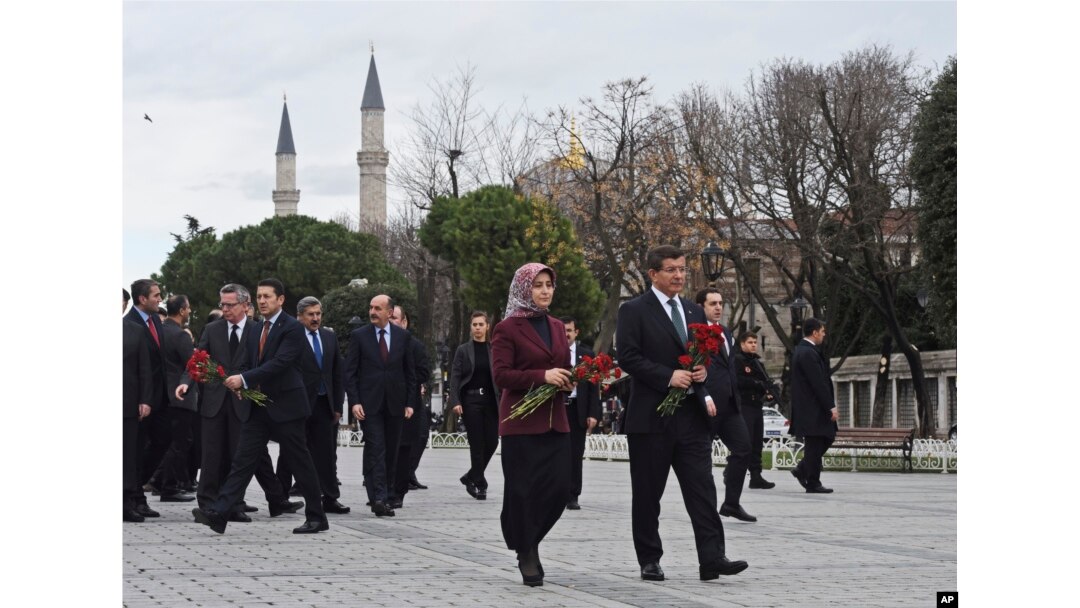 Turkey's Prime Minister Ahmet Davutoglu, right, accompanied by his wife Sare, visit the site of Tuesday's explosion, in the historic Sultanahmet district of Istanbul, Wednesday, Jan. 13, 2016.