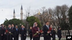 Perdana Menteri Turki Ahmet Davutoglu, kanan, ditemani oleh istrinya Sare, mengunjungi lokasi ledakan Selasa lalu (12/1), di distrik bersejarah Sultanahmet di Istanbul, Rabu, 13 Januari 2016.