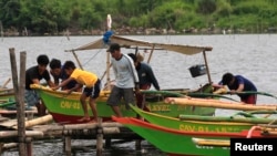 Residents secures their small boat in a safer area in preparations for the strong winds brought by Typhoon Rammasun, locally name Glenda, in a coastal area of Cavite city, south of Manila, July 15, 2014.
