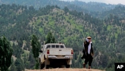 FILE - A Taliban militant is seen walking in Pakistan's tribal region of North Waziristan, Aug. 12, 2013. American author Paul Overby was reportedly hoping to reach the region when he went missing in May of 2014.