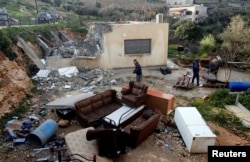 Palestinians check the damage after Israeli forces demolished a house in the village of Al-Walaja near Bethlehem, in the Israeli-occupied West Bank, Feb. 11, 2019.