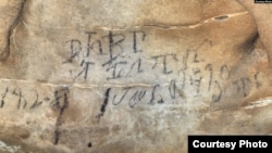 An inscription on the Manitou Cave wall, written in the Cherokee syllabary, identifies writers as stickball team leader and is dated April 30, 1828. (Photo courtesy Beau Carroll, archaeologist, Eastern Band of Cherokee)