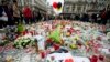 FILE - Three balloons in the colors of the Belgian flag fly as people mourn the victims of the bombings at Place de la Bourse in central Brussels, Belgium, March 24, 2016. 