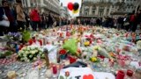 FILE - Three balloons in the colors of the Belgian flag fly as people mourn for the victims of the bombings at the Place de la Bourse in the center of Brussels, Belgium, March 24, 2016. 