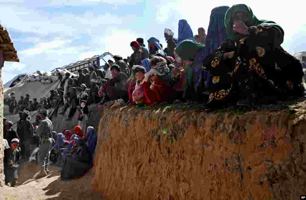 Survivors wait to receive food donations near the site of the landslide that buried Abi-Barik village in Badakhshan province, northeastern Afghanistan, May 6, 2014.