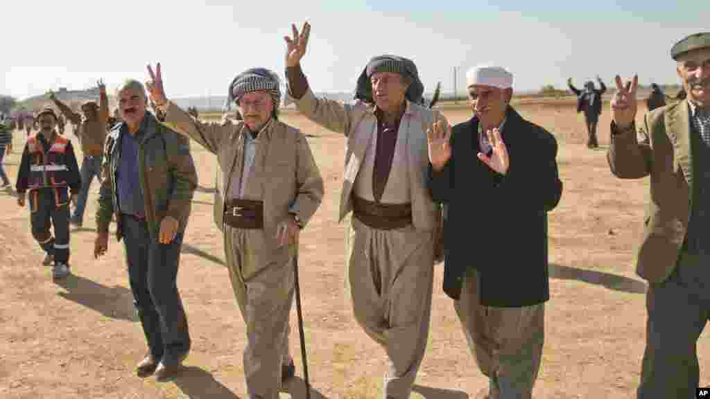 Des Kurdes font le signe de victoire après un rassemblement de solidarité avec des Syriens à la cité de Kobané dans le village de Caykara, Turquie, le 11 novembre 2014.