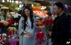 A couple buys flowers to celebrate Valentine's Day, in Islamabad, Pakistan, Feb. 13, 2017. A Pakistani judge has banned Valentine's Day celebrations in the country's capital, saying they are against Islamic teachings.