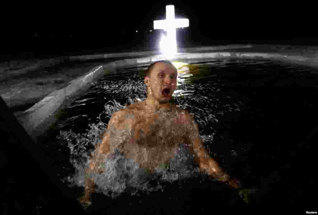 A man takes a dip in the icy waters of a lake on the eve of Orthodox Epiphany in Minsk, Belarus.