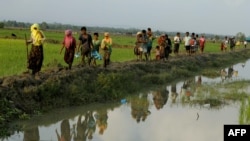 Displaced Rohingya refugees from Rakhine state in Myanmar carry their belongings as they flee violence, near Ukhia, near the border between Bangladesh and Myanmar on September 4, 2017. - A total of 87,000 mostly Rohingya refugees have arrived in Banglades