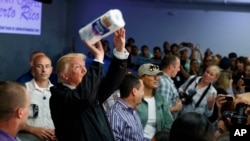 El presidente de Estados Unidos Donald Trump, entregando toallas de papel a los puertorriqueños en su visita a la isla.