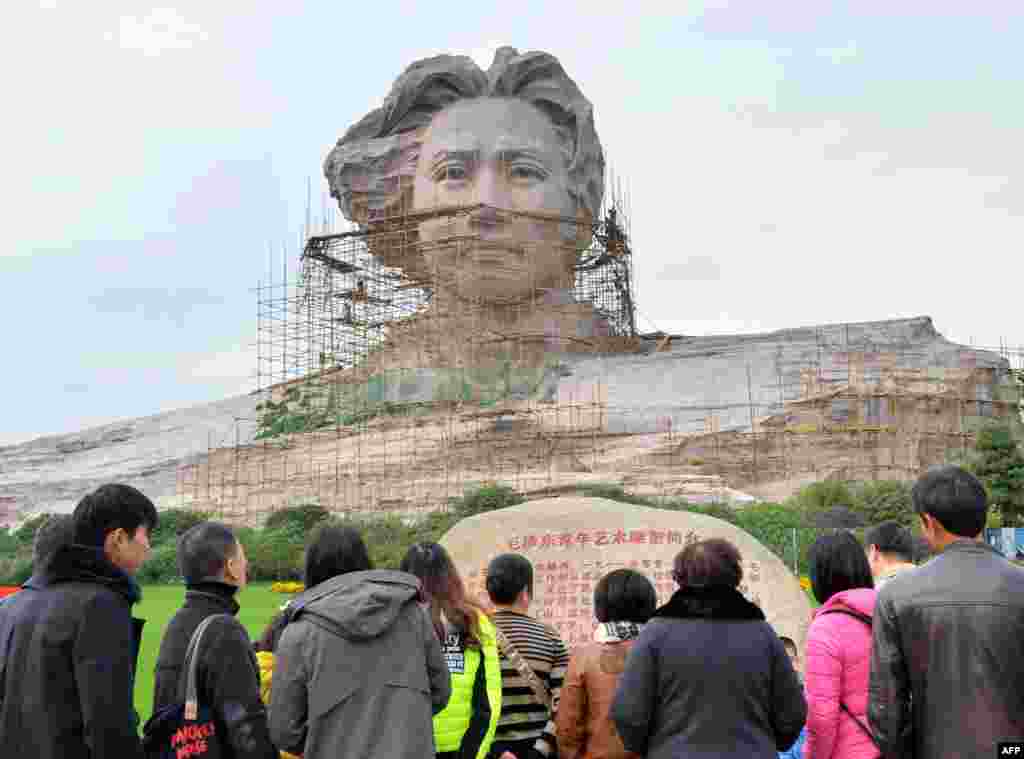 Tourists visit an under construction statue of Mao Zedong in Changsha, central China's Hunan province, Nov. 26, 2013, ahead of the 120th anniversary of Mao's birth, which China will celebrate on December 26.