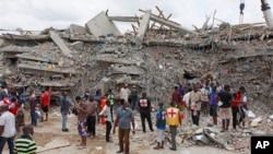 FILE - In this photo taken Sept. 13, 2014, rescue workers search for survivors in the rubble of a collapsed building belonging to the Synagogue Church of All Nations in Lagos, Nigeria. 