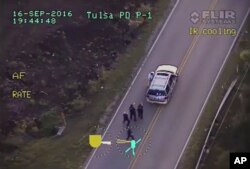 In this image made from a Friday, Sept. 16, 2016 police video, Terence Crutcher, top, is pursued by police officers as he walk to an SUV in Tulsa, Okla.