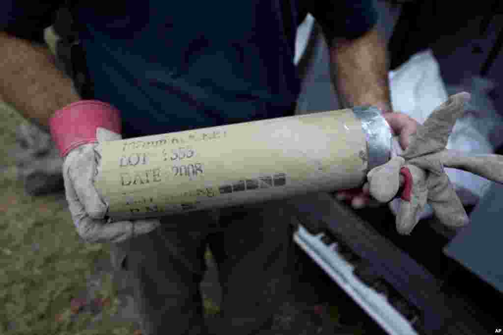 An Israeli police man holds the remains of a rocket fired by Palestinian militants after it hit a community along the Israel - Gaza Border, southern Israel, October 24, 2012. 