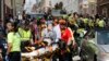 FILE - In this Aug. 12, 2017, photo, rescue personnel help injured people who were hit when a car ran into a large group of protesters after a white nationalist rally in Charlottesville, Va. 