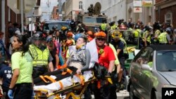 FILE - In this Aug. 12, 2017, photo, rescue personnel help injured people who were hit when a car ran into a large group of protesters after a white nationalist rally in Charlottesville, Va. 