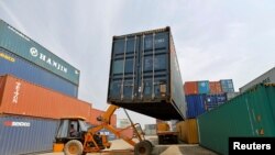 FILE - A mobile crane carries a container at Thar Dry Port in Sanand in the western state of Gujarat, India, Feb. 13, 2017. 