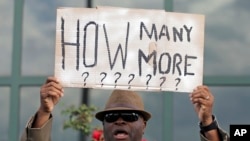 FILE - Rev. Arthur Prioleau holds a sign during a protest in the shooting death of Walter Scott at city hall in North Charleston, S.C., Wednesday, April 8, 2015. Scott was killed by a North Charleston police officer after a traffic stop. 