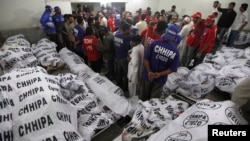 Rescue workers and residents gather to identify relatives at a morgue after a bomb blast in a residential area in Karachi March 3, 2013.
