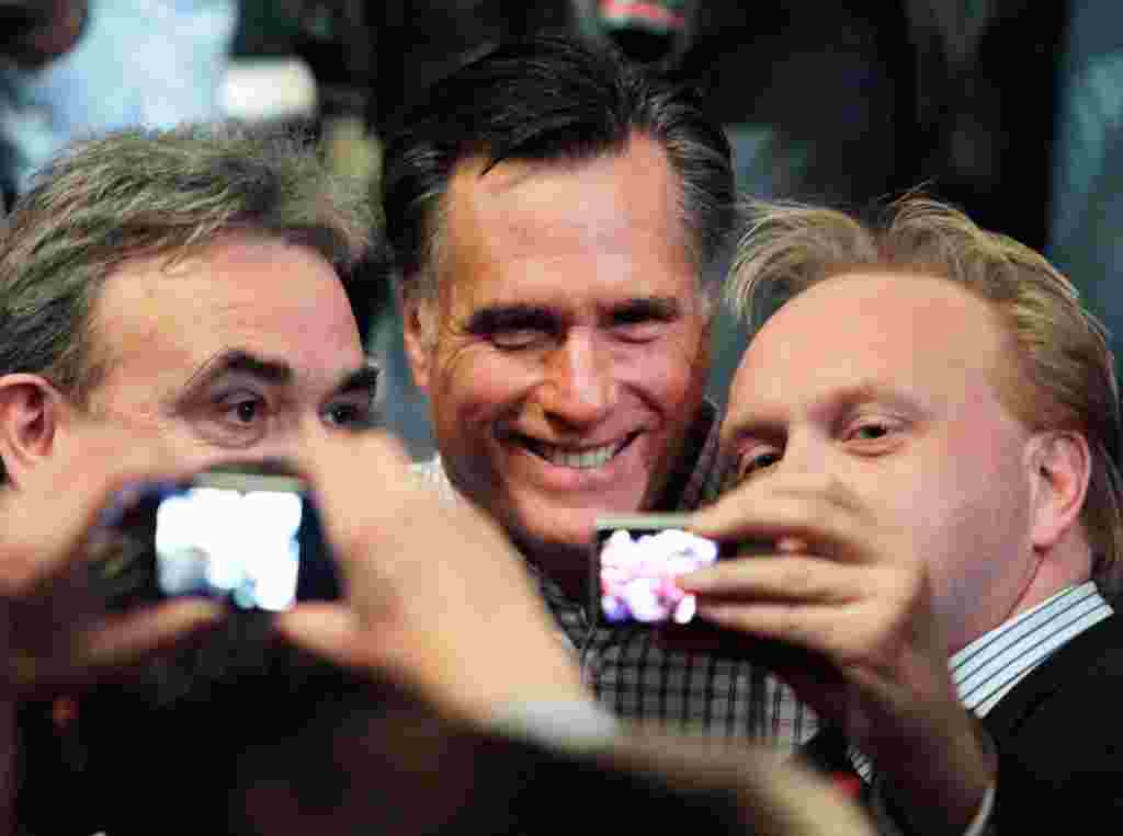 Bakal calon dari Partai Republik Mitt Romney berpose bersama para pendukungnya di Gedung Opera Rochester, New Hampshire, 8 Januari (AP).