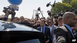 French centrist presidential candidate Emmanuel Macron, center, enters his car after a ceremony marking 102nd anniversary of the slaying of Armenians by Ottoman Turks in a brief ceremony, April 24, 2017 in Paris.