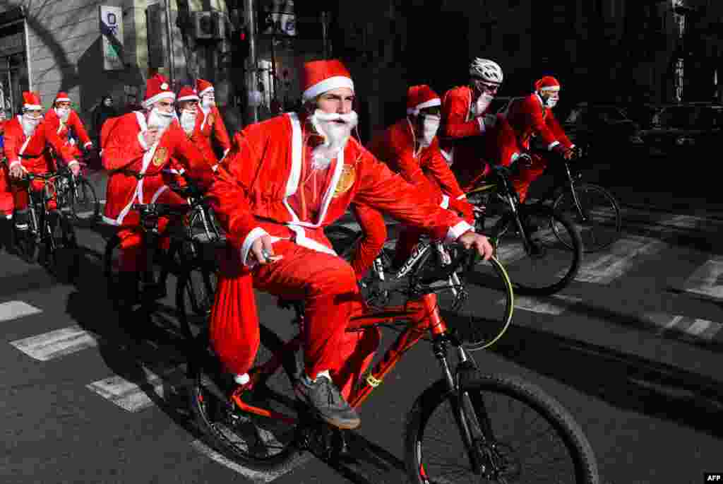 People dressed as Santa Claus ride their bicycles through the streets of Tbilisi, Georgia.