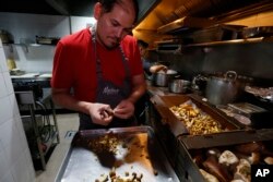 Chef Eduardo Garcia, founder of Maximo Bistrot and former migrant worker in the US, cuts mushrooms at his restaurant in Mexico City, July 13, 2017.