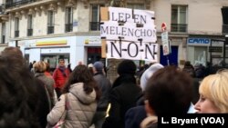 A marcher brandishes a sign against both far-right leader Marine Le Pen and far-left leader Jean-Luc Melenchon, both of whom critics accuse of anti-semitic discourse. 