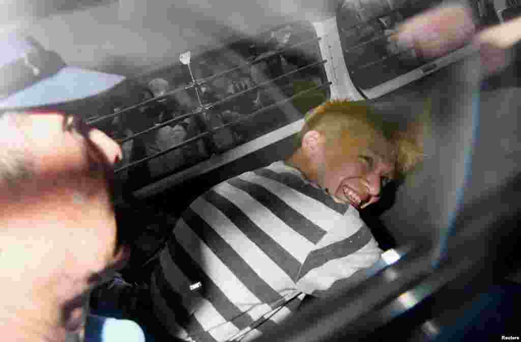 Satoshi Uematsu, suspected of a deadly attack at a facility for the disabled, is seen inside a police car as he is taken to prosecutors, at Tsukui police station in Sagamihara, Kanagawa prefecture, Japan, in this photo taken by Kyodo.