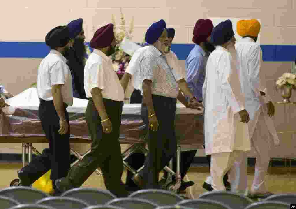 Sikh temple members bring in a casket for the funeral and memorial service for the six victims of the Sikh Temple of Wisconsin mass shooting, August 10, 2012.
