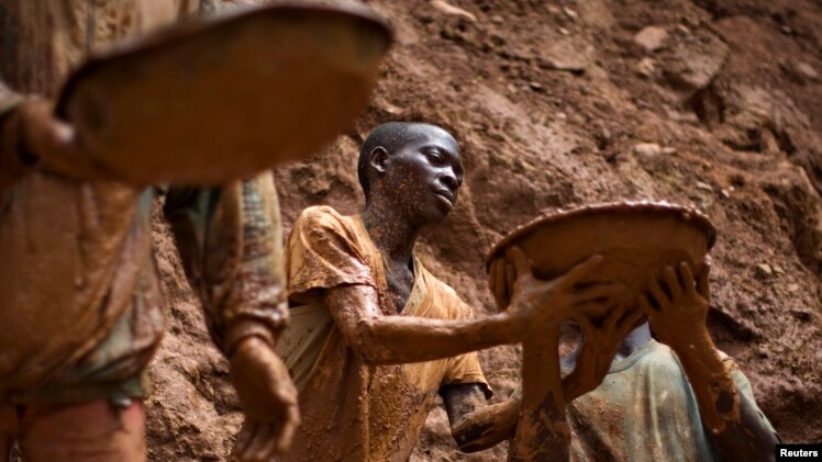 FILE - Gold miners form a human chain while digging an open pit at the Chudja mine near the village of Kobu in northeastern Congo, Feb. 23, 2009.