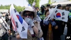 Supporters of former South Korean President Park Geun-hye weep to demand her release as a bus carrying her arrives at the Seoul Central District Court in Seoul, South Korea, May 25, 2017. 