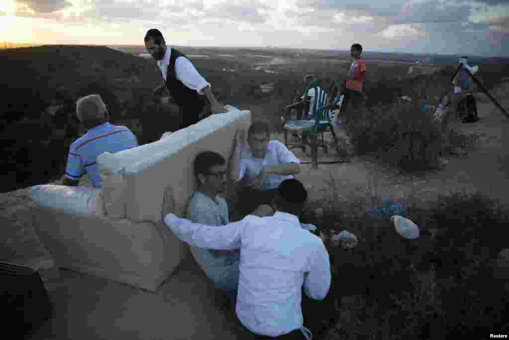 Israelis gather to look at the Gaza Strip from a hilltop near the southern town of Sderot, July 15, 2014.