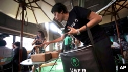 Japan Uber: A delivery man brings ordered food during a press conference of UberEats in Tokyo, Wednesday, Sept. 28, 2016.