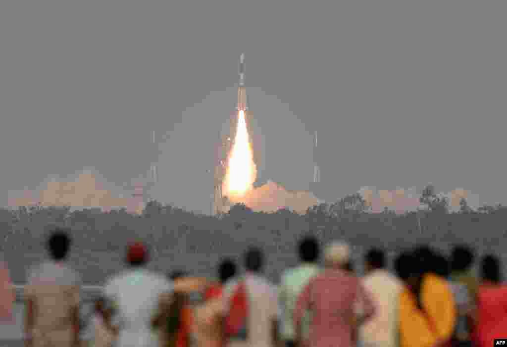 Indian onlookers watch as the Indian Space Research Organisation&#39;s (ISRO) GSAT-6A communications satellite launches on the Geosynchronous Satellite Launch Vehicle (GSLV-F08) from Sriharikota in the southern state of Andhra Pradesh.