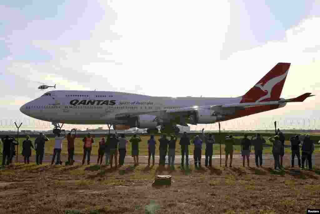 People watch the last Qantas 747 jet depart Sydney Airport in Sydney, Australia, as Qantas retires its remaining Boeing 747 planes early due to the coronavirus disease (COVID-19) outbreak.