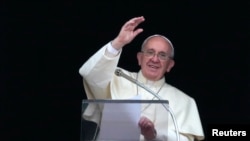 Pope Francis waves during his Angelus prayer in Saint Peter's Square at the Vatican, Dec. 26, 2013. 