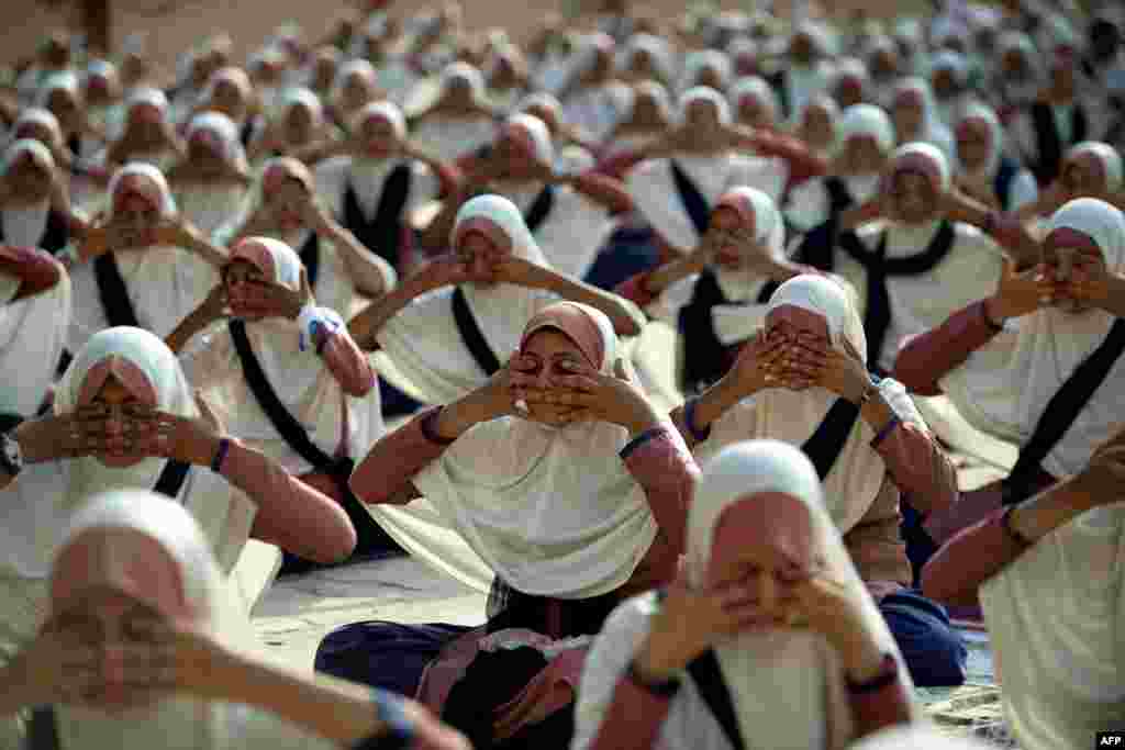 Indian students attend a yoga workshop conducted by teachers from the Sri Sri Ravi Shankar Institute at the FD Higher Secondary School in Ahmedabad, to mark World Yoga Day.