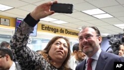 Elisa Jimenez, director of the California Mental Health Connection, takes a selfie with Mexico's Secretary of Foreign Relations Luis Videgaray at the dedication of a mental health facility at the Consulate General of Mexico in Los Angeles, Sept. 12, 2017.